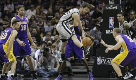 Pemain San Antonio Spurs, Tiago Splitter (tengah), kehilangan bola di tengah kepungan pemain Los Angeles Lakers di laga playoff NBA di San Antonio, Texas, Rabu (24/4). 