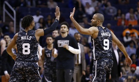 Pemain San Antonio Spurs, Tony Parker (kanan) dan Patty Mills, melakukan selebrasi high-five after usai mencetak poin saat menghadapi Phoenix Sun dalam pertandingan basket NBA di Phoenix pada Rabu (7/2). 