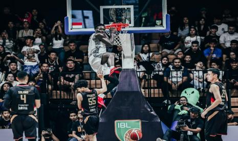 Pemain Satria Muda Pertamina Dame Diagne melakukan dunk dalam pertandingan IBL 2024 melawan Dewa United, Sabtu (6/7/2024).