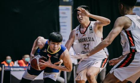 Pemain Satria Muda Pertamina Laurentius Steven Oei membawa bola berusaha melewati pertahanan Indonesia Patriots dalam pertandingan Indonesia Basketball League (IBL) 2021 di Robinson Resort, Cisarua, Bogor, Jumat (19/3) malam.