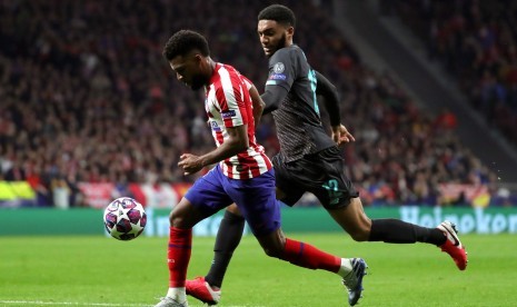 Pemain sayap Atletico Madrid Thomas Lemar (kiri) berebut bola dengan bek Liverpool Joe Gomez (kanan)