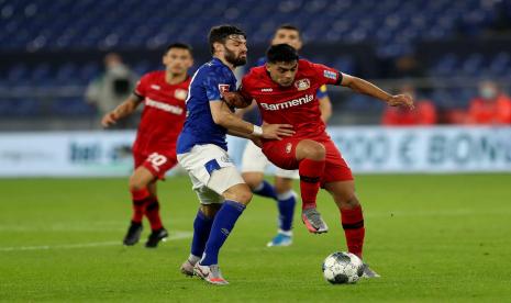 Pemain Schalke 04 Daniel Caligiuri (kiri) berebut bola dengan gelandang Bayer Leverkusen Nadiem Amiri pada pertandingan Bundesliga di Veltins-Arena, Gelsenkirchen, Jerman yang berakhir Senin (15/6) dini hari WIB. Kedua tim bermain imbang 1-1.