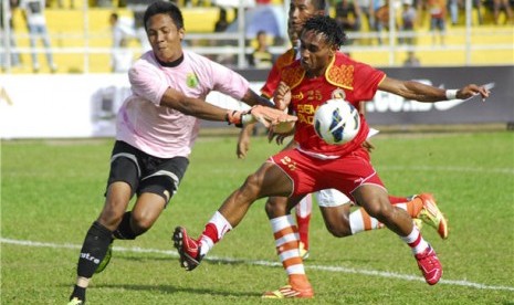 Pemain Semen Padang FC, Titus Bonay (kanan), berebut bola penjaga gawang Persibo Bojonegoro, Ngurah Aria, pada pertandingan Community Shield 2013 di Stadion H. Agus Salim Padang, Sumbar, Minggu (10/2). 