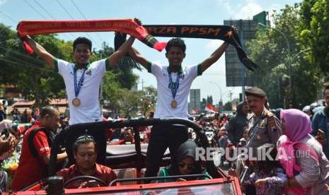 Pemain sepak bola kembar Timnas U-16 Bagas Kaffa (kiri) dan Bagus Kaffi (kanan) menyapa warga saat dikirab keliling Kota Magelang, Jawa Tengah, Rabu (15/8).