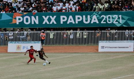 Pemain sepak bola Papua Rafiko B Nawipa (kanan) berusaha melewati hadanagan pemain Nangroe Aceh Darussalam pada babak final sepak bola putra PON Papua di Stadion Mandala, Kota Jayapura.