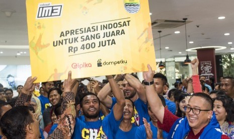 Pemain sepak bola Persib Bandung mengangkat hadiah simbolis disaksikan President Director dan CEO Indosat Alexander Rusli (kanan) dan Manager Persib Bandung Umuh Muchtar (kiri) saat perayaan kemenangan di kantor Indosat, Jakarta, Senin (19/10).