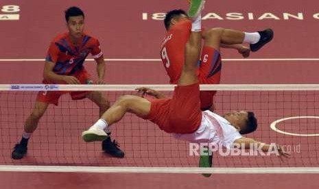 Pemain sepak takraw putra Indonesia Nofrizal (bawah) menendang bola dihalangi pemain Filipina Emmanuel Escote (atas) saat pertandingan penyisihan tim ganda putra sepak takraw Asian Games 2018 di GOR Ranau, Jakabaring Sport City (JSC), Palembang, Sumatra Selatan, Kamis (23/8).