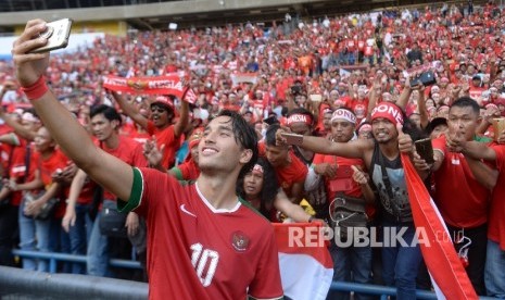   Pemain sepakbola Indonesia Ezra Walian melakukan swafoto bersama suporter usai melawan Kamboja pada kualifikasi Sepakbola SEA Games 2017 Kuala Lumpurdi Stadion Shah Alam, malaysia, Kamis (24/8). 