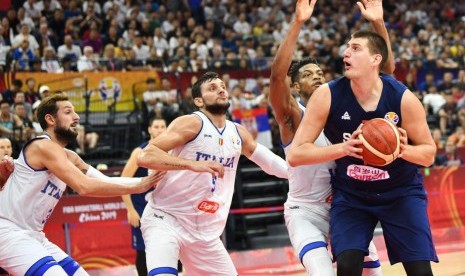 Pemain Serbia Nikola Jokic (kanan) dijaga para pemain Italia dalam pertandingan Piala Dunia FIBA 2019.