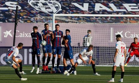 Pemain Sevilla FC Joan Jordan (kiri) melepas tendangan bebas saat melawan Levante di Stadion Camilo Cano, Alicante, Spanyol, Selasa (16/6) dini hari WIB. Sevilla ditahan imbang Levante 1-1. 