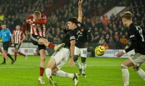 Pemain Sheffield United, Oliver McBurnie (kiri), mencetak gol ke gawang Manchester United (MU).