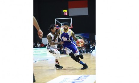 Pemain SM Pertamina Jamar Andre Johnson dijaga pemain BSB Hangtuah Kelly Purwanto dalam gim pertama semifinal divisi merah IBL Pertaliate 2017/2018