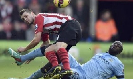 Pemain Southampton Morgan Schneiderlin (kiri) berjibaku dengan gelandang Manchester City Yaya Toure dalam pertandingan Liga Primer Inggris, Ahad (30/11).