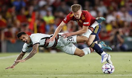 Pemain Spanyol Dani Olmo (kanan) berduel memperebutkan bola melawan pemain Portugal Joao Cancelo dalam pertandingan UEFA Nations League di Stadion Benito Villamarin, Sevilla, Andalusia, Spanyol, Jumat (3/6/2022) dini hari WIB. 