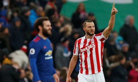 Pemain Stoke City, Erik Pieters (kiri) merayakan gol bunuh diri yang dibuat gelandang Manchester United, Juan Mata (kanan) pada laga Liga Primer di stadion Bet365, Sabtu (21/1). United tertinggal satu gol pada babak pertama.