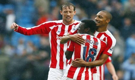 Pemain Stoke City, Mame Diouf (tengah), melakukan selebrasi bersama dua rekannya Peter Crouch (kiri) dan Steven N'Zonzi (kanan) usai menjebol gawang Manchester City di laga Liga Primer Inggris di Etihad stadium, Manchester, Sabtu (30/8). 