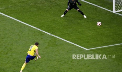 Pemain Swedia Marcus Berg menendang  bola ke gawang Swiss pada pertandingan babak 16 besar Piala Dunia 2018 di Stadion St. Petersburg, Rusia, Selasa (3/7). 