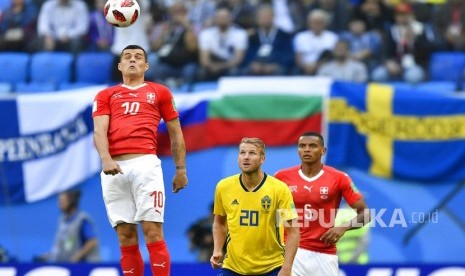 Pemain Swiss Granit Xhaka (kiri) menyundul  bola pada pertandingan babak 16 besar Piala Dunia 2018 di Stadion St. Petersburg, Rusia, Selasa (3/7). 