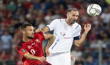 Pemain Swiss Haris Seferovic, kiri, berjuang untuk sundulan melawan pemain Italia Giorgio Chiellini selama pertandingan sepak bola kualifikasi grup C Piala Dunia 2022 antara Swiss dan Italia di stadion St. Jakob-Park di Basel, Swiss, pada hari Minggu, 5 September 2021. 