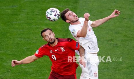 Pemain Swiss Haris Seferovic, kiri, menantang pemain Spanyol Aymeric Laporte pada pertandingan perempat final kejuaraan sepak bola Euro 2020 antara Swiss dan Spanyol di Stadion Saint Petersburg di St. Petersburg, Rusia, Jumat (2/7).