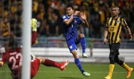 Pemain Thailand Adisak Kraisorn mencetak gol ke gawang Malaysia dalam pertandingan Grup B di Stadion Jalan Besar, Singapura, Rabu (26/11).