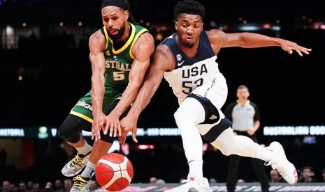 Pemain tim basket Australia Patty Mills (kiri) berebut bola dengan pemain Amerika Serikat Donovan Mitchell.