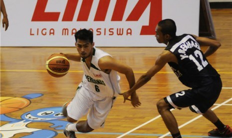 Pemain tim Institut Perbanas, Rahul Tamara Putra (kiri), berusaha melewati hadangan pemain lawan dalam pertandingan lanjutan Greater Jakarta Conference Liga Mahasiswa (LIMA) di GOR Tanjung Priuk, Jakarta Utara.  