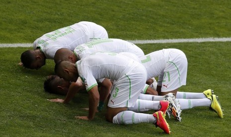 Pemain Timnas Aljazair melakukan sujud syukur setelah Sofiane Feghouli menjebol gawang Belgia dalam laga Grup H Piala Dunia 2014 Brasil di Stadion Mineirao, Belo Horizonte, Selasa (17/6). 