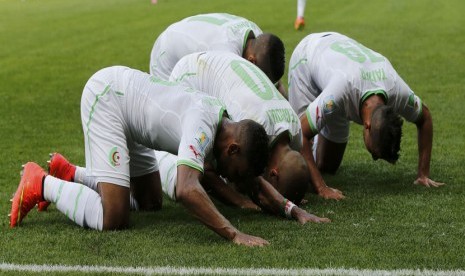 Pemain Timnas Aljazair, Sofiane Feghouli, melakukan selebrasi sujud syukur usai menjebol gawang Belgia di laga Grup H Piala Dunia 2014 Brasil di Stadion Mineiroa, Belo Horizonte, Selasa (17/6). 