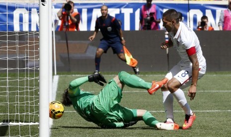 Pemain timnas Amerika Serikat, Clint Dempsey (kanan), menceploskan bola ke gawang kiper timnas Turki, Onur Recep Kivrak, dalam laga internasional di Harrison, New Jersey, Ahad (1/6). 