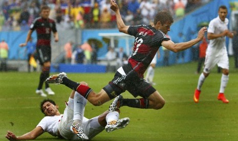 Pemain Timnas Amerika Serikat, Omar Gonzalez, melanggar gelandang serang Jerman, Thomas Mueller (kanan), saat kedua tim bertemu di laga terakhir Grup G Piala Dunia 2014 Brasil di Arena Pernambuco, Recife, Kamis (26/6). 