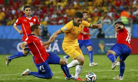 Pemain Timnas Australia, Matthew Leckie (tengah), menggiring bola di tengah kepungan pemain Cile di laga Grup B Piala Dunia 2014 di Arena Pantanal, Cuiaba, Jumat (13/6). 