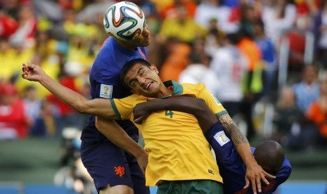 Pemain Timnas Belanda, Ron Vlaar (kiri) dan Bruno Martins Indi, berebut bola dengan pemain Australia, Tim Cahill (tengah), dalam laga Grup B Piala Dunia 2014 Brasil di Stadion Beira Rio, Porto Alegre, Rabu (18/6). 