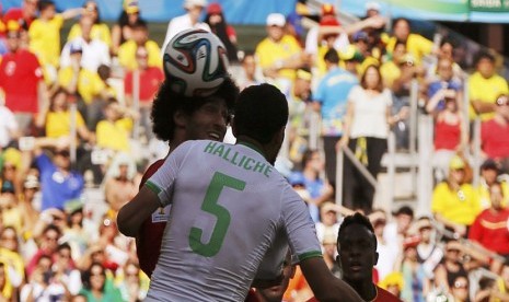 Pemain Timnas Belgia, Marouane Fellaini (kiri), melepaskan sundulan menjebol gawang Aljazair di laga Grup H Piala Dunia 2014 Brasil di Stadion Mineirao, Belo Horizonte, Selasa (17/6). 