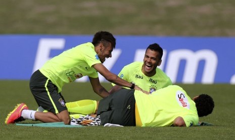 Pemain Timnas Brasil, Neymar (kiri) dan Dani Alves (tengah), bercand di sela sesi latihan di Teresopolis, Rio de Janeiro, Ahd (1/6). 