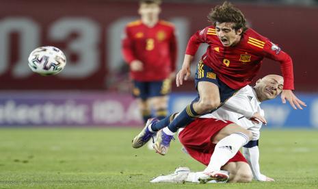 Pemain Timnas Georgia Jaba Kankava (kanan) menjegal penggawa Spanyol Gerard Moreno pada laga babak pertama kualifikasi Puala Dunia 2022 di Tbilisi, Georgia, Ahad (28/3) malam WIB.