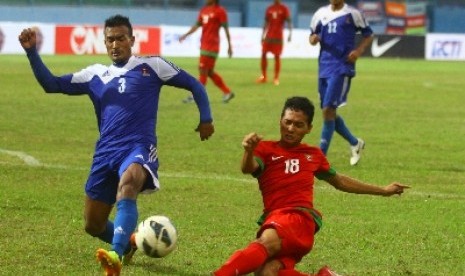 Pemain timnas Indonesia, Anindito Wahyu (kanan) berebut bola dengan pemain Nepal, Biraj Maharian.