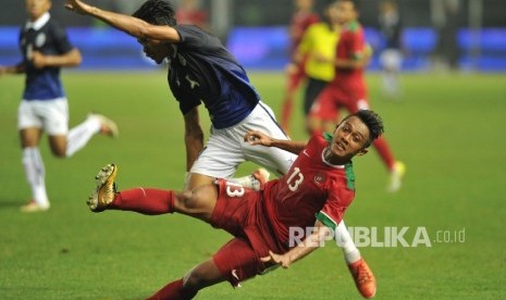 Pemain timnas Indonesia Febri Haryadi terjatuh seusai berebut bola dengan pemain lawan dalam laga uji coba melawan Kamboja di Stadion Patriot Chandrabhaga, Bekasi, Rabu (4/10).