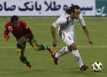 Pemain Timnas Indonesia, Firman Utina (kanan), dan pemain Timnas Iran Ali Karimi (Kiri) berjibaku menguasai lapangan tengah dalam pertandingan kualifikasi Grup E Asia Pra Piala Dunia, Jumat malam di Teheran. Iran menang telak 3-0.