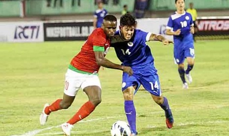 Pemain Timnas Indonesia, Greg Nwokolo (kiri) saling berebut bola dengan pemain Filipina, Carlos Alberto De Muga, dalam partai persahabatan di Stadion Manahan, Solo, Jateng, Rabu (14/8). 