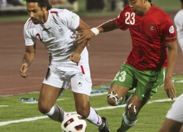 Pemain Timnas Indonesia, Hamka (kanan), dan pemain Timnas Iran Farhad Majidi (kiri) berebut bola dalam pertandingan kualifikasi Grup E Asia Pra Piala Dunia di Teheran, Jumat malam. Iran menang telak 3-0.