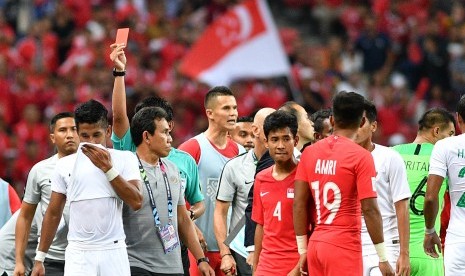 Pemain timnas Indonesia Putu Gede Juni Antara (kedua kiri) meninggalkan lapangan setelah terkena kartu merah saat melawan timnas Singapura dalam penyisihan grub B Piala AFF 2018 di Stadion Nasional Singapura, Jumat (9/11/2018). Indonesia kalah 0-1 dalam pertandingan perdana tersebut.