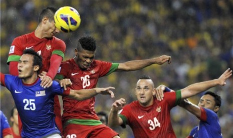 Pemain timnas Indonesia, Raphael Maitimo (kiri atas), terlibat duel udara dengan pemain Malaysia, Wan Zack Haikal (kiri bawah), pada pertandingan babak penyisihan grup B Piala AFF 2012 di stadion Bukit Jalil, Kuala Lumpur, Malaysia, Sabtu (1/12). 