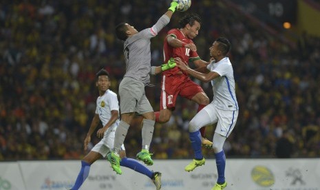 Pemain Timnas Indonesia U-22 Ezra Walian (tengah) berebut bola dengan pemain Timnas Malaysia U-22 Adam Nor bin Azlin (kiri) dan Kiper Muhammad Haziq bin Nadzli dalam babak semi final SEA Games XXIX Kuala Lumpur di Stadion Majlis Perbandaran Selayang, Malaysia, Sabtu (26/8).