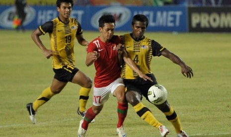 Pemain timnas Indonesia U-22 Riyanto (tengah) berebut bola dengan pemain timnas Malaysia U-22 Reuben Thayaparan (kanan) pada pertandingan SCTV Cup 2012 di Stadion Utama Gelora Bung Karno (SUGBK) Senayan, Jakarta, Ahad (9/9) malam