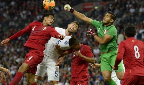 Pemain timnas Inggris, Gary Cahill (dua kiri), terlibat duel udara dengan kiper Peru, Raul Fernandez (dua kanan), dalam laga internasional di Stadion Wembley, London, Jumat (30/5). 