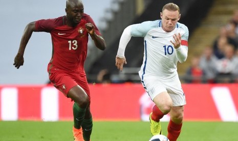 Pemain Timnas Inggris, Wayne Rooney (kanan), berusaha mengamankan bola dari kejaran pemain Portugal, Danilo (kiri), dalam laga internasional di Stadion Wembley, London, pada 2 Juni. 