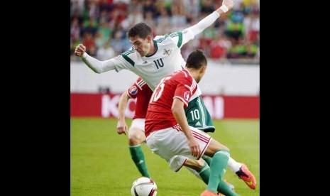 Pemain Timnas Irlandia Utara, Kyle Lafferty (tengah), berebut bola dengan pemain Hungaria di laga pembuka Grup F Piala Eropa 2016 di Budapest, Hungaria, Ahad (7/9). 