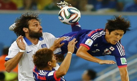 Pemain Timnas Jepang, Atsuto Uchida (kanan), dilanggar pemain Yunani, Giorgios Samaras (kiri), di laga Grup C Piala Dunia 2014 di Arena Dunas, Natal, Kamis (19/6). 