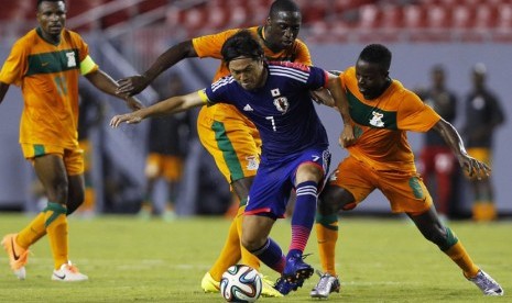 Pemain Timnas Jepang, Yasuhito Endo (dua kanan), mendapat pengawalan ketat pemain Zambia dalam laga uji coba di Tampa, Florida, Jumat (6/6). 